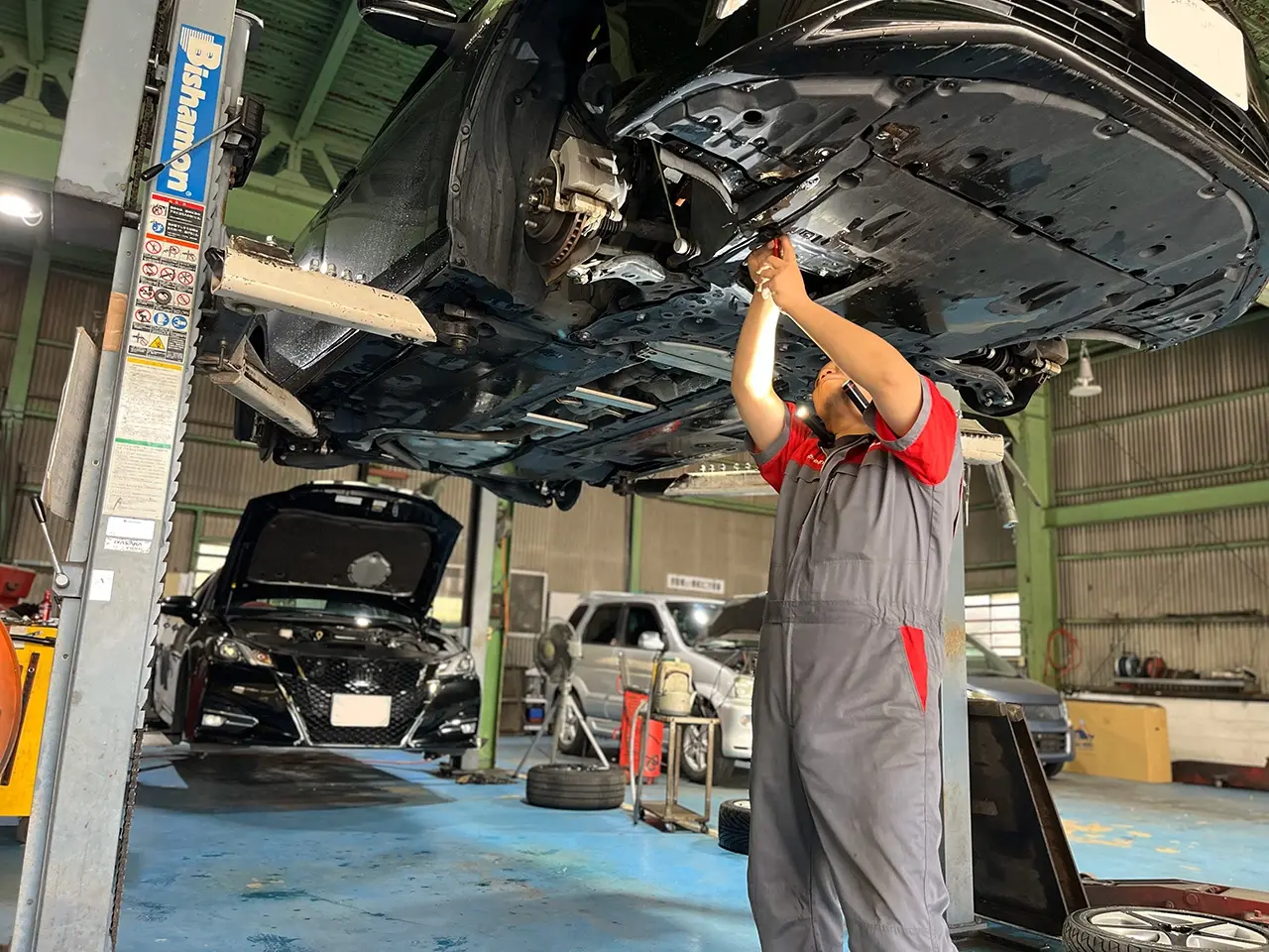 車の下で整備している様子